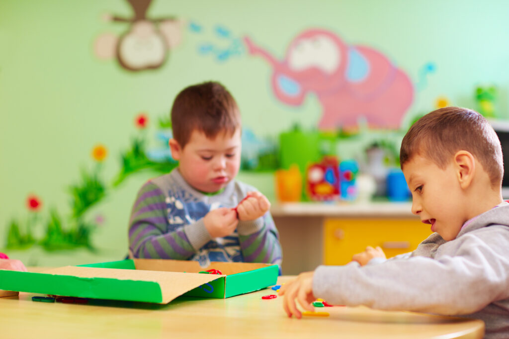 Two boys playing indoors at a special needs daycare.